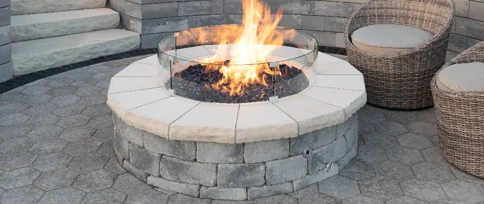 Circular gas-burning fire pit with chairs on a patio in Huron, OH.