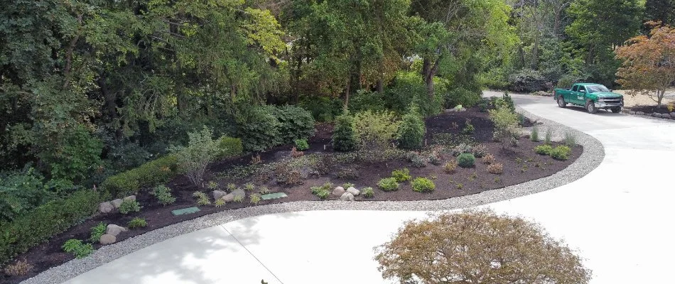Landscape bed along a driveway in Huron, OH, with plants and mulch.