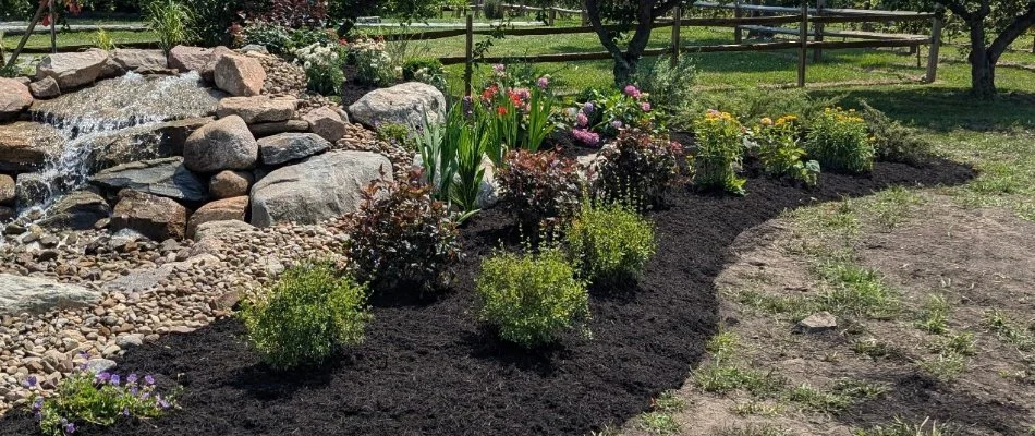 Landscape bed in Huron, OH, with mulch, plants, and flowers.