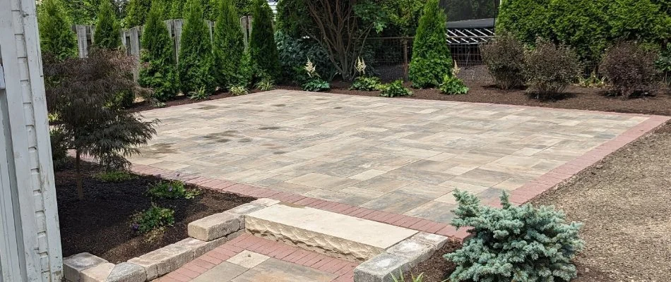 Natural stone patio in Huron, OH, with green plantings.