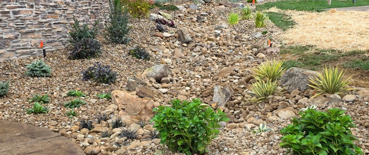 Landscape in Huron, OH, with rock ground cover and green shrubs.