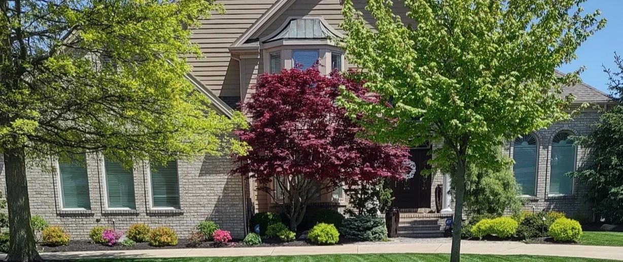 A large house in Huron, OH, with a green lawn and landscaping.