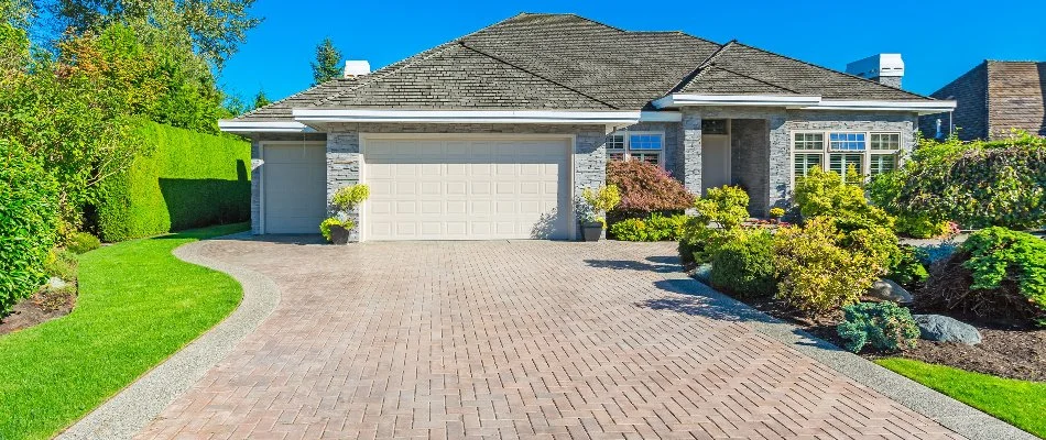 House in Huron, OH, with paver driveway and lush plants.