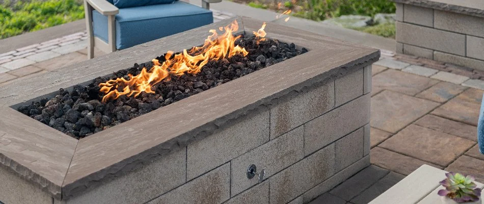 Sleek, rectangular fire pit in Marblehead, OH, with blue chairs.